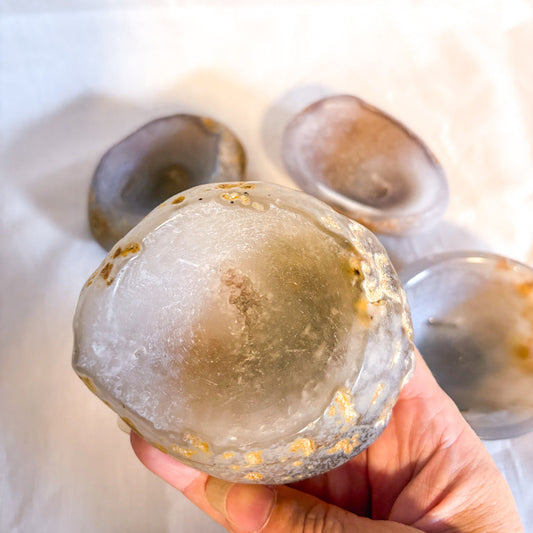 Hand holding a translucent crystal-like object with a blurred background