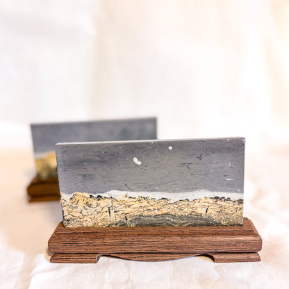 Decorative object with a landscape scene on a wooden stand against a light background