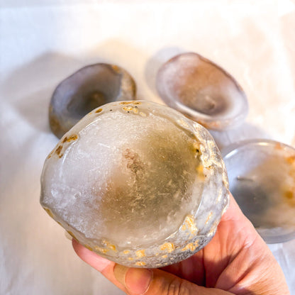Hand holding a translucent crystal-like object with a blurred background