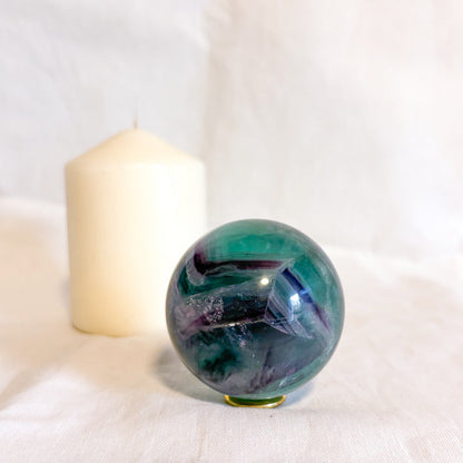 Fluorite crystal polished sphere with rainbow inclusions 330g