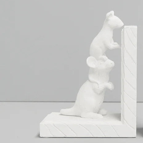 A pair of white decorative bookends shaped like mice, set against a clean light gray studio background.