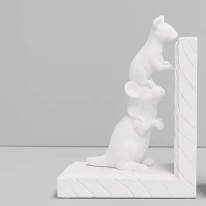 A pair of white decorative bookends shaped like mice, set against a clean light gray studio background.