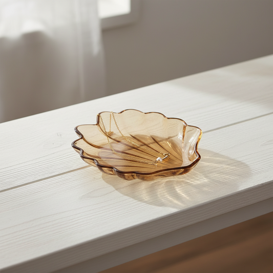 A scallop-shaped glass dish with a ribbed fan design.