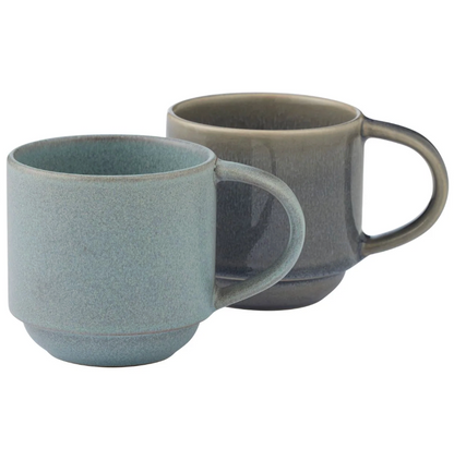 Ceramic mugs with a speckled glaze in muted blue-gray and taupe tones.